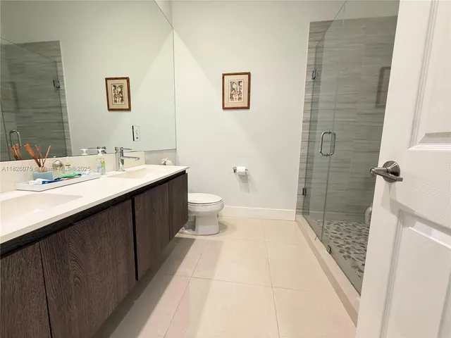 a bathroom with a sink a toilet a shower and a mirror
