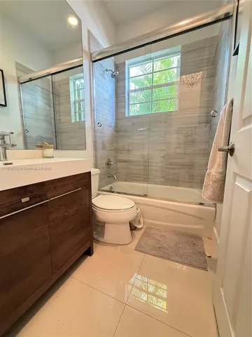 a bathroom with a sink a toilet a mirror and a shower