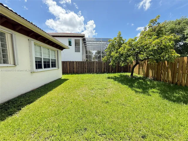a view of a house with backyard and garden