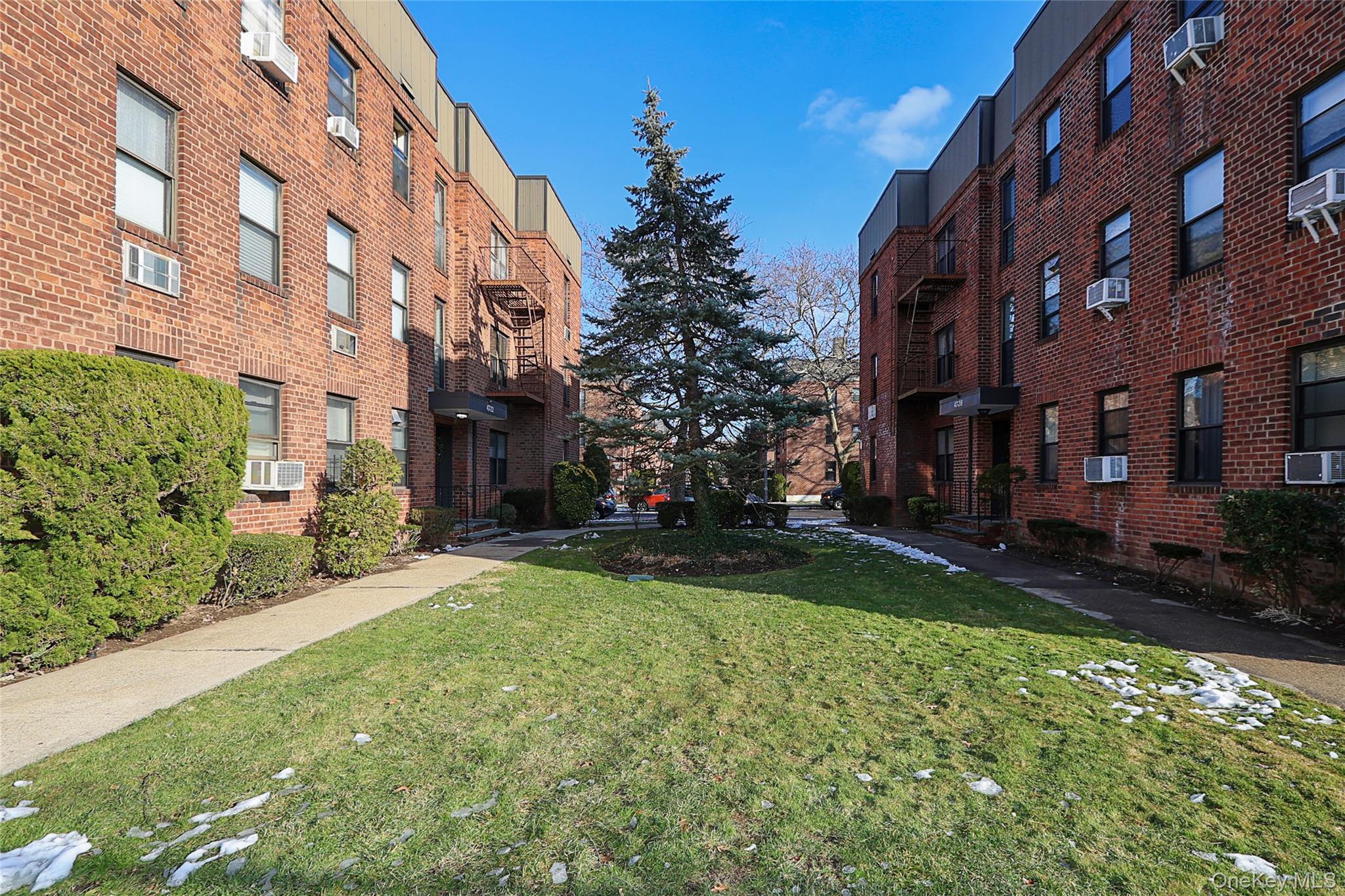 47-22 215th Place, Unit 2C Queens, NY 11361 - Photo 26 of 26 Surrounding community featuring a lawn
