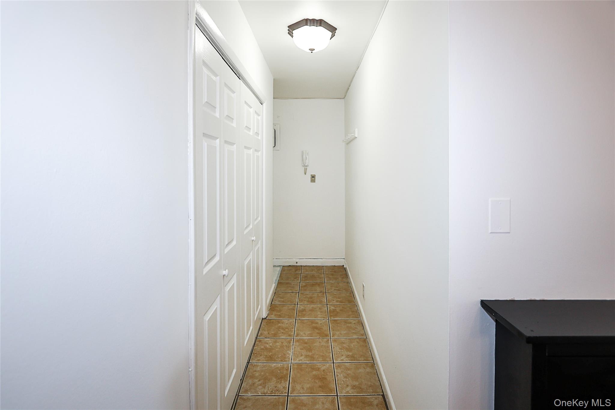 47-22 215th Place, Unit 2C Queens, NY 11361 - Photo 3 of 26 Corridor featuring light tile patterned floors and baseboards