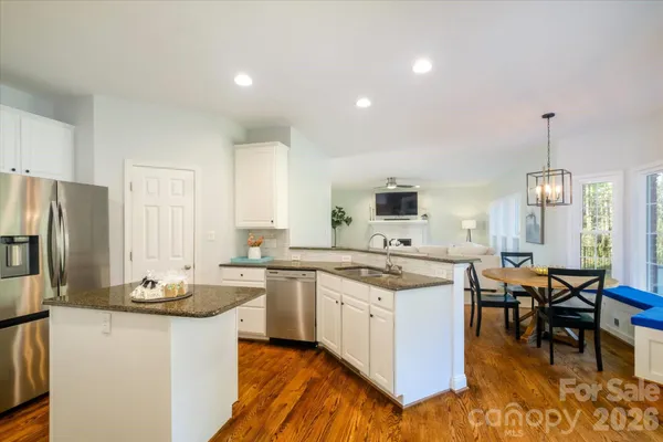 a kitchen with stainless steel appliances kitchen island granite countertop a sink a stove and a refrigerator