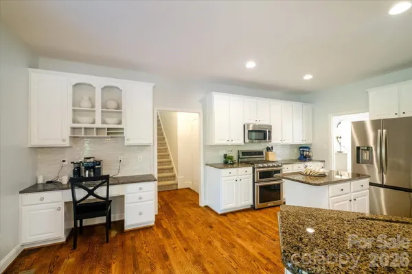 a kitchen with stainless steel appliances granite countertop a refrigerator stove microwave and sink