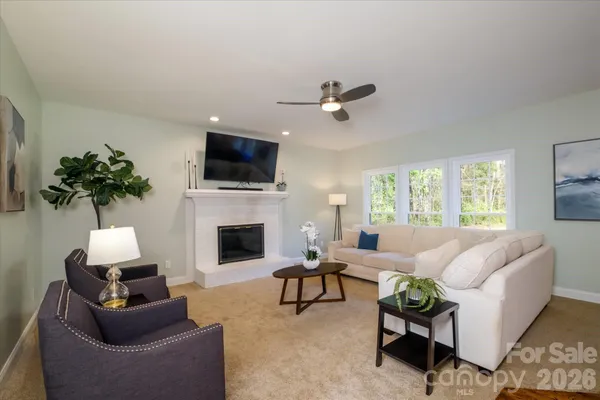 a living room with furniture a fireplace and a flat screen tv