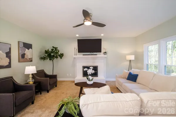 a living room with furniture a fireplace and a flat screen tv