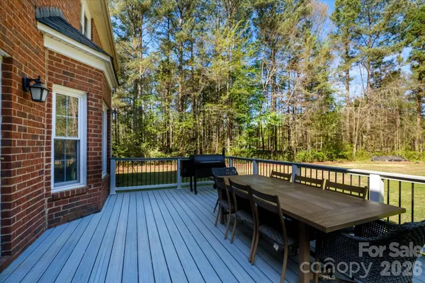 a view of a patio with table and chairs with wooden floor and fence