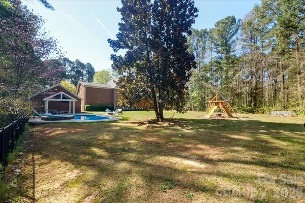 a view of a house with pool and trees