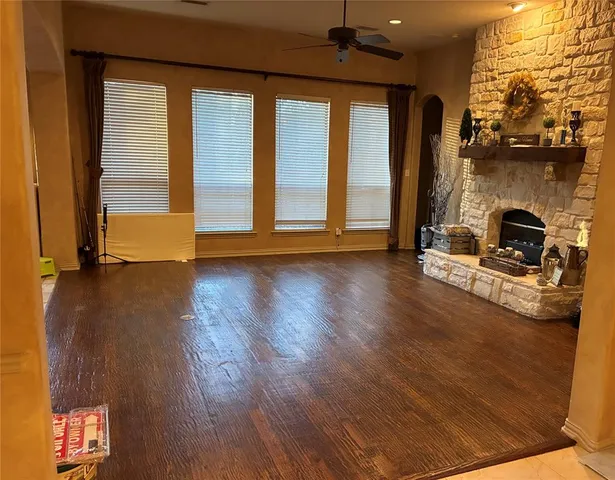 a view of a livingroom with wooden floor and a fireplace