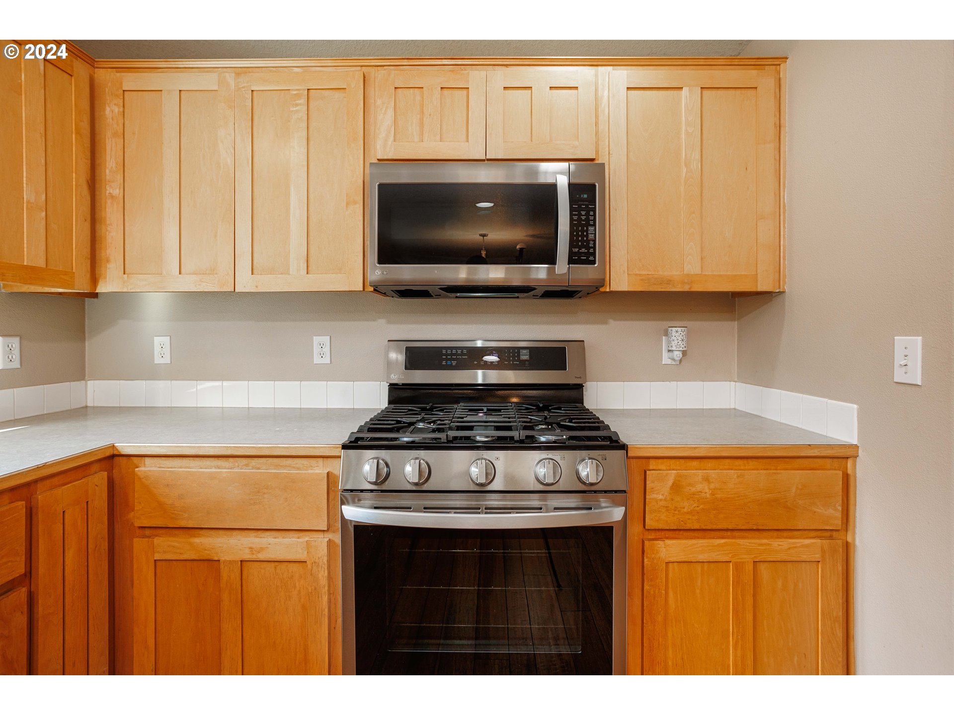 633 North 18th Place Ridgefield, WA 98642 - Photo 12 of 31 a kitchen with stainless steel appliances granite countertop a stove a microwave and a sink