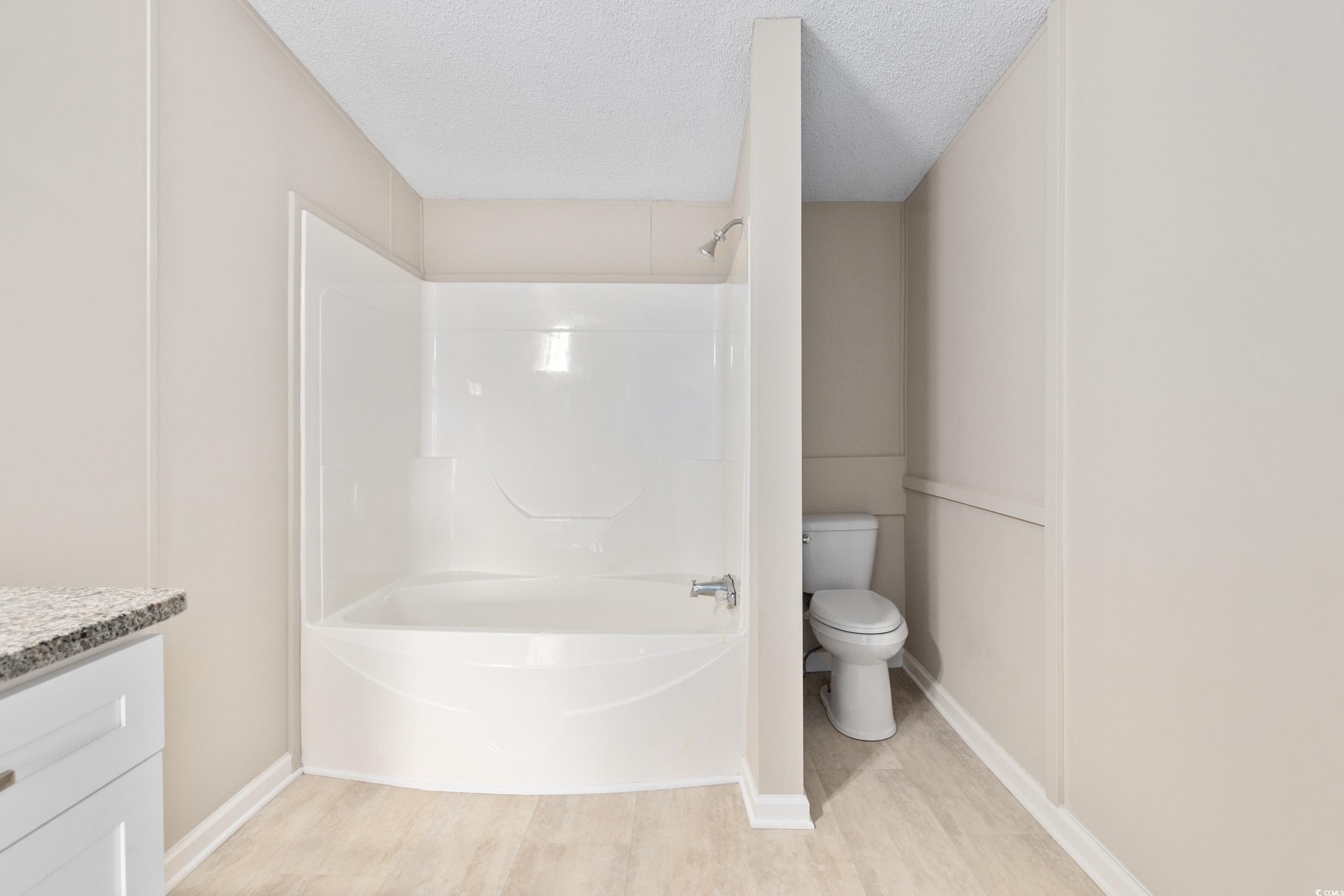 3106 Dog Bluff Road Aynor, SC 29511 - Photo 15 of 27 Bathroom with a textured ceiling, vanity, shower / tub combination, and light wood-style floors
