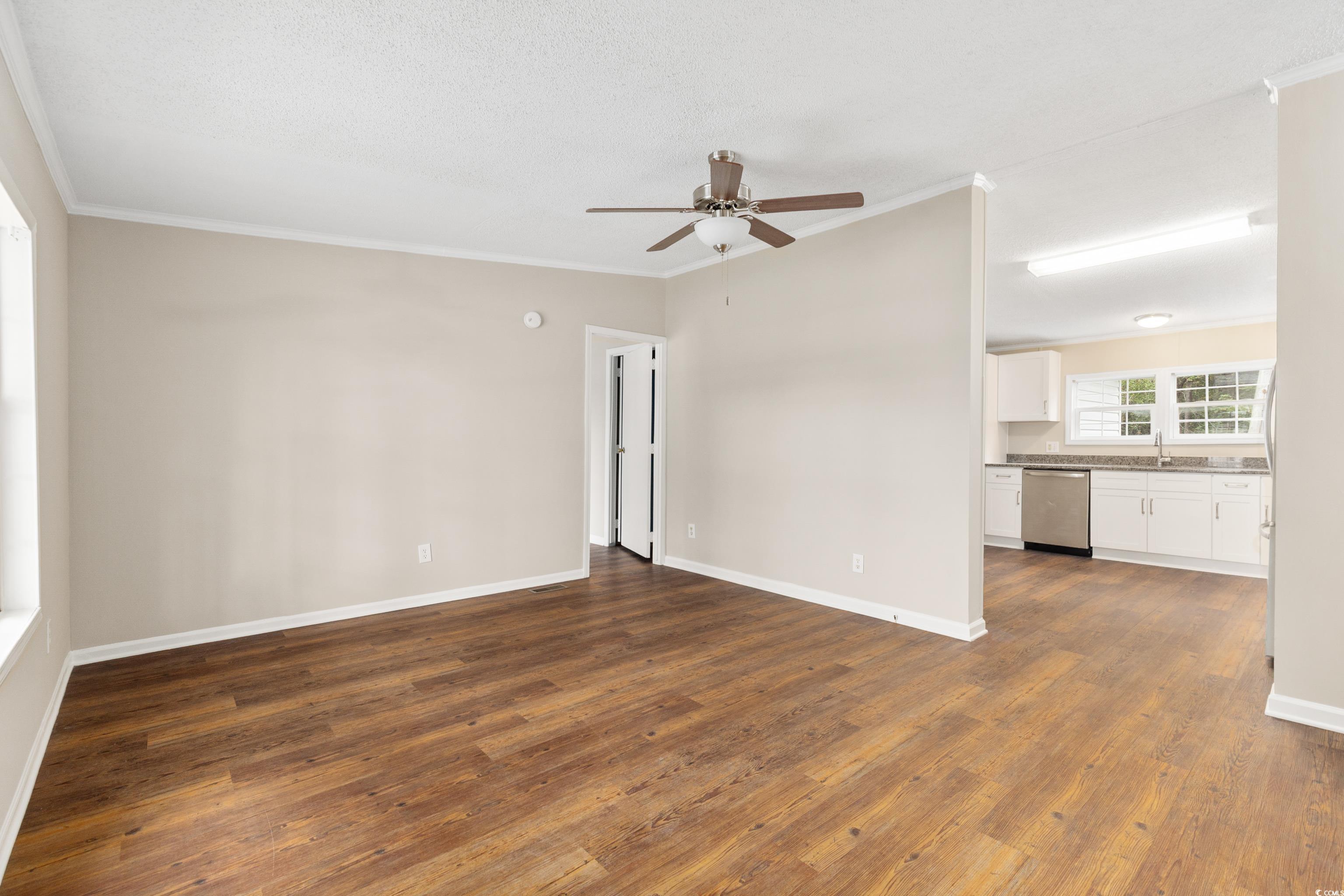 3106 Dog Bluff Road Aynor, SC 29511 - Photo 7 of 27 Unfurnished room featuring crown molding, dark wood-style flooring, ceiling fan, and a textured ceiling