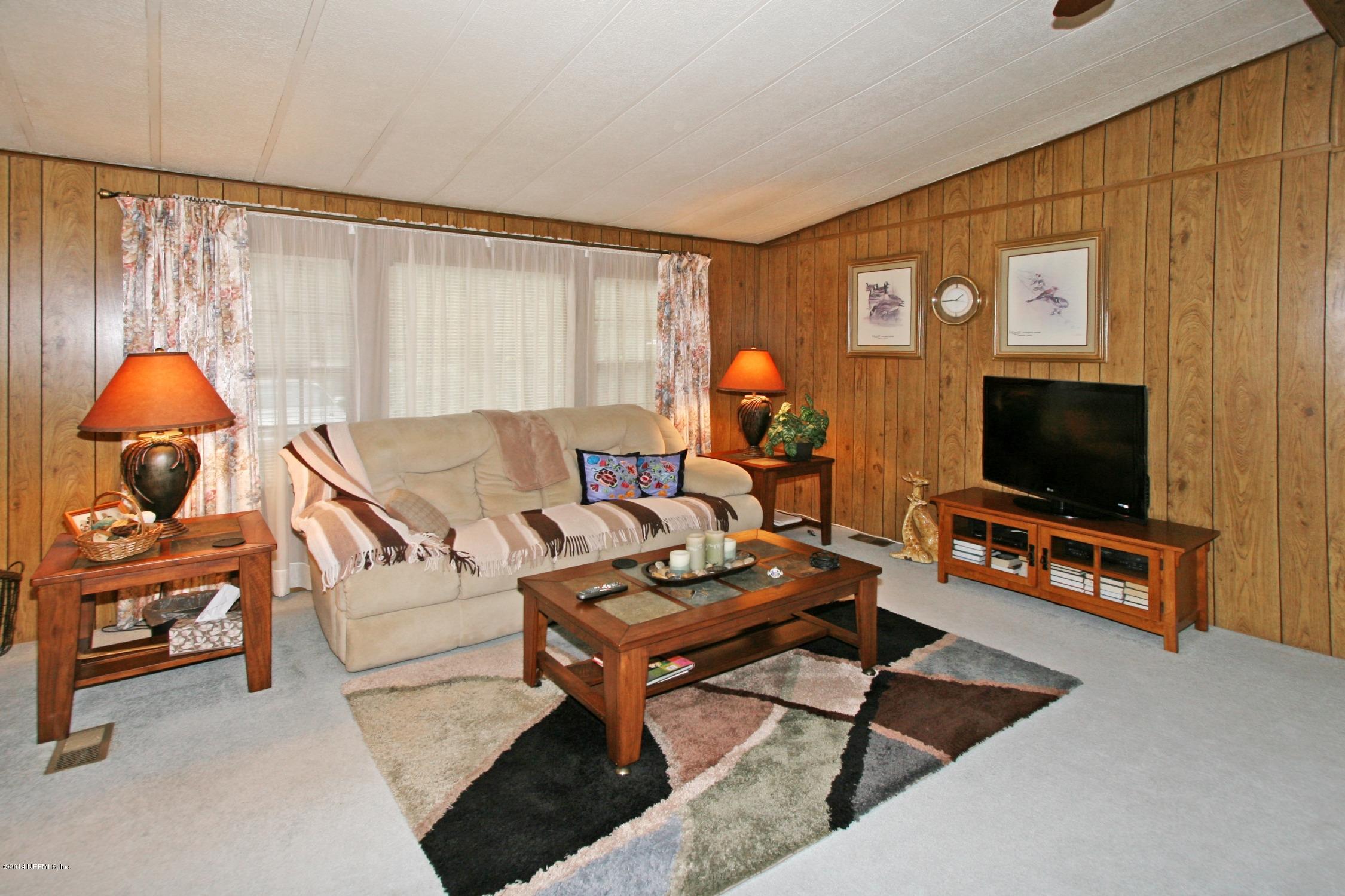 9894 Hood Road Jacksonville, FL 32257 - Photo 3 of 14 a living room with furniture and a flat screen tv
