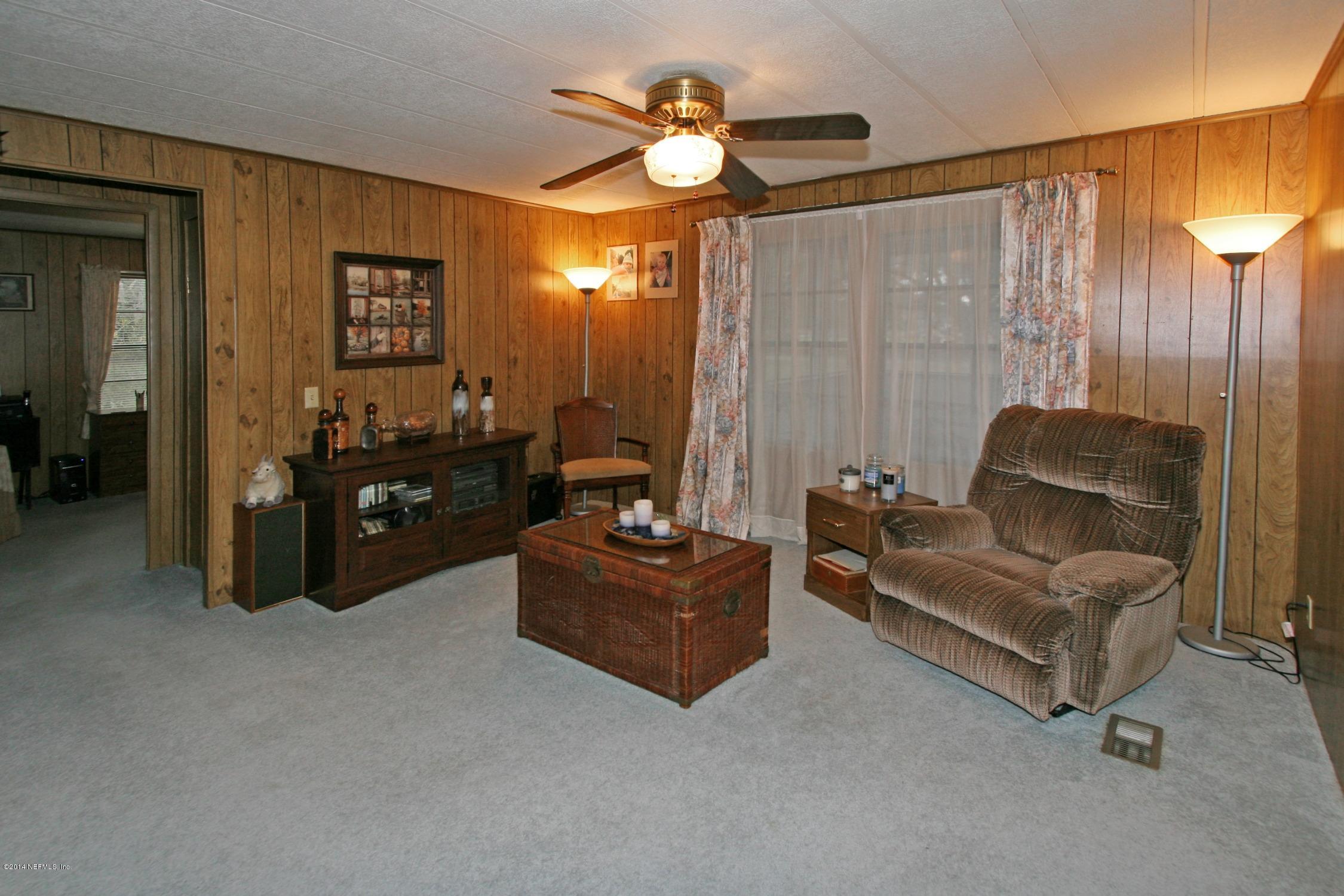 9894 Hood Road Jacksonville, FL 32257 - Photo 4 of 14 a living room with furniture and a chandelier