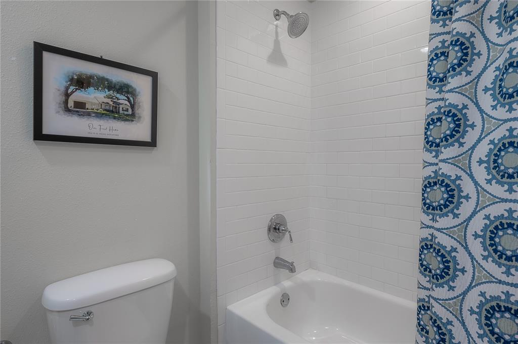 3108 West Villa Rosa Street Tampa, FL 33611 - Photo 34 of 58 a white bath tub sitting next to a white toilet and a shower curtain