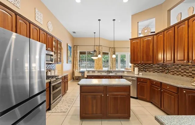 a kitchen with stainless steel appliances granite countertop a sink a stove and a refrigerator