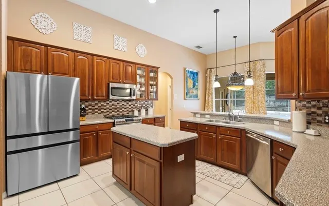 a kitchen with stainless steel appliances granite countertop a sink stove and refrigerator