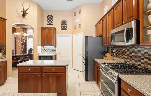 a kitchen with stainless steel appliances granite countertop a refrigerator and a stove