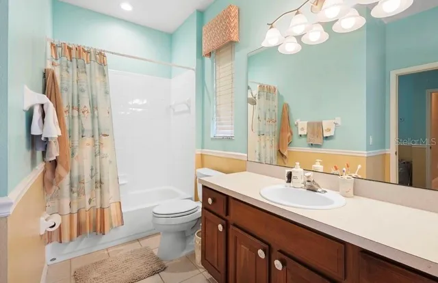 a bathroom with a sink a toilet and a large mirror