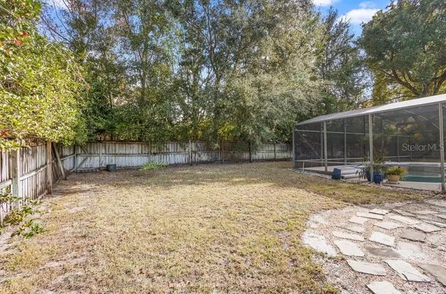 a view of a house with backyard and a tree