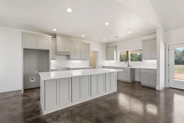 a kitchen with kitchen island white cabinets and window