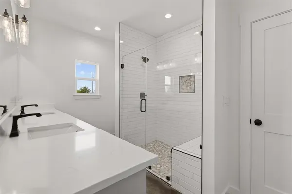 a spacious bathroom with a shower sink and mirror