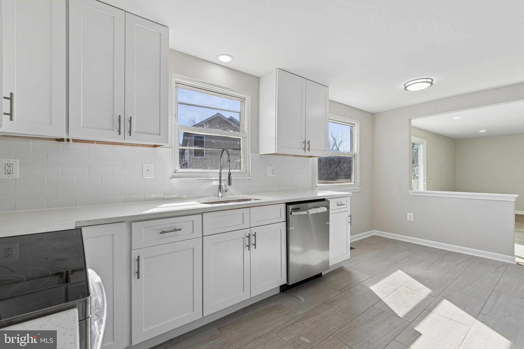 7451 Oakland Mills Road Columbia, MD 21046 - Photo 32 of 83 a kitchen with white cabinets appliances a sink and a window