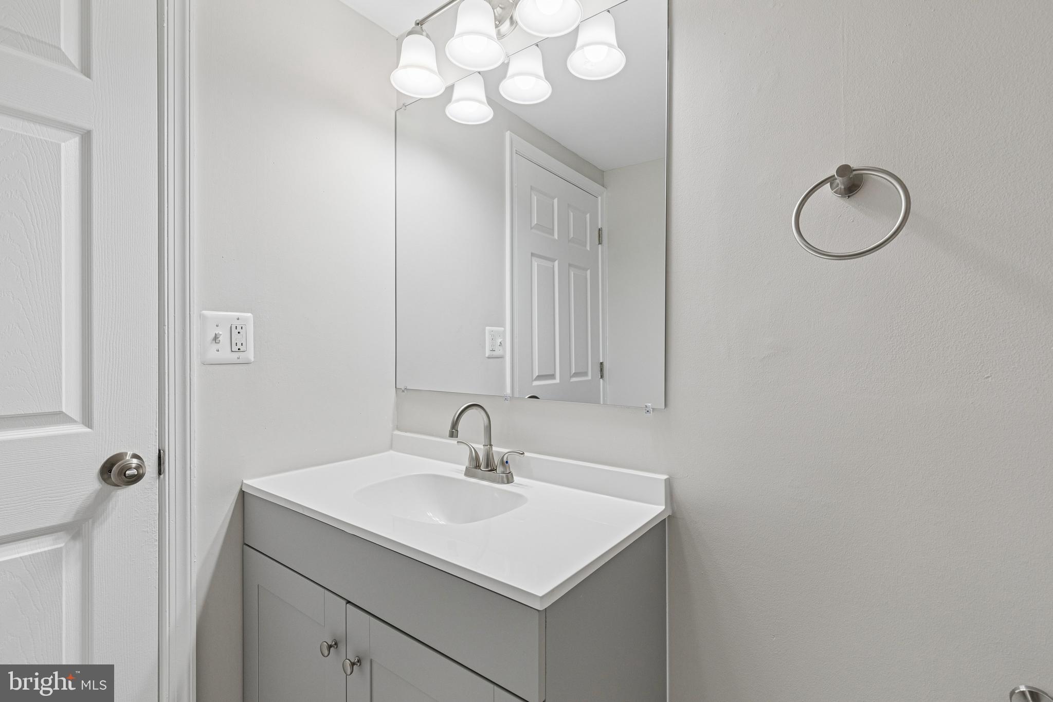 7451 Oakland Mills Road Columbia, MD 21046 - Photo 53 of 83 a bathroom with a sink a light fixture and a mirror