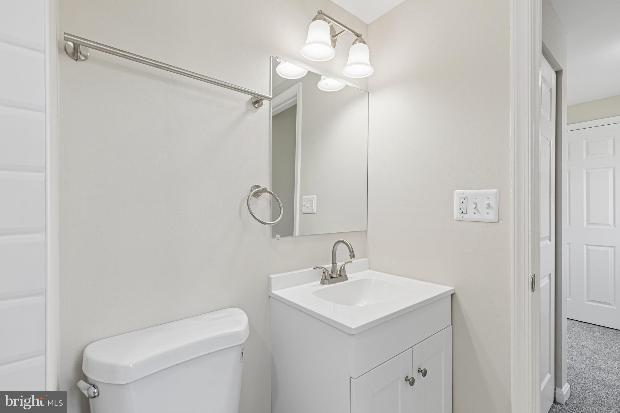 7451 Oakland Mills Road Columbia, MD 21046 - Photo 62 of 83 a bathroom with a toilet a sink a mirror and shower