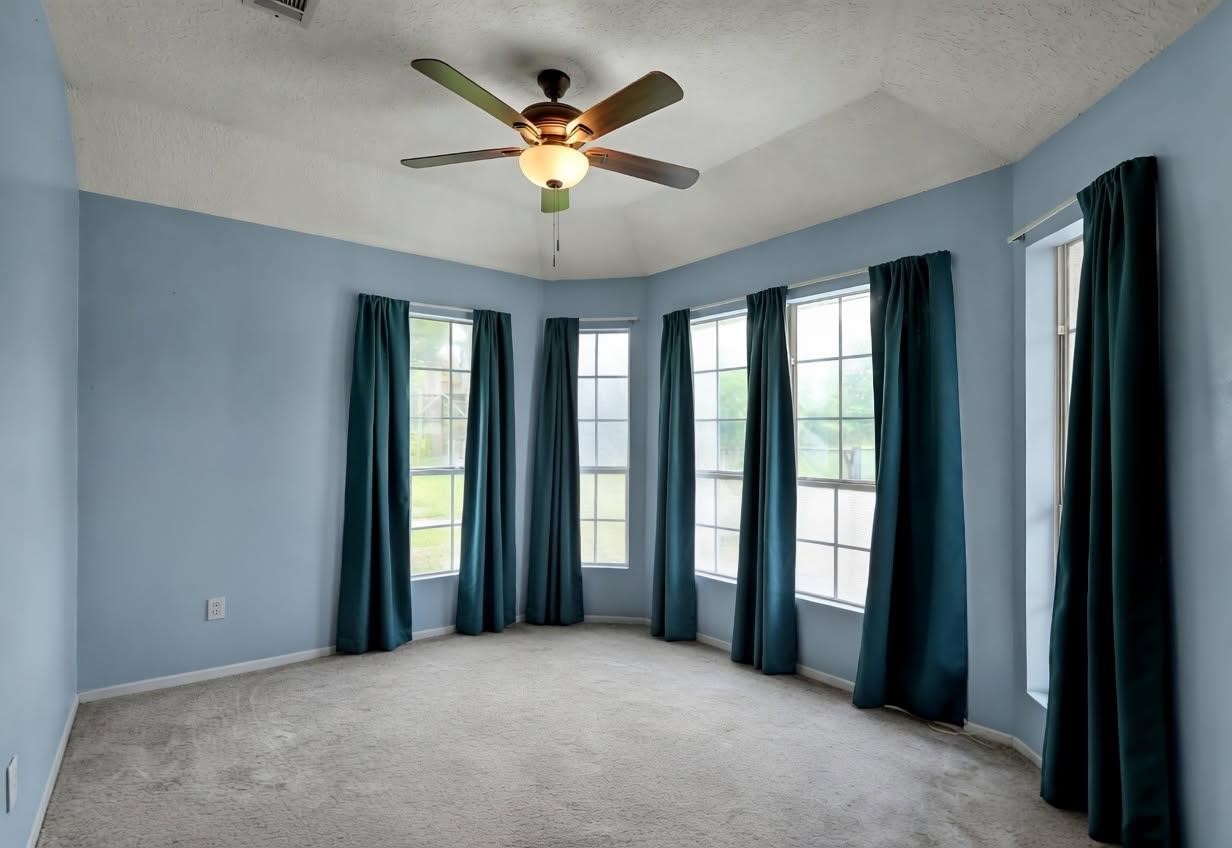251 Petty Road Waller, TX 77484 - Photo 12 of 25 an empty room with chandelier fan and windows