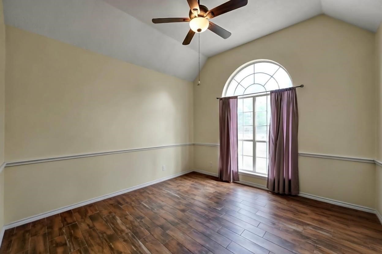 251 Petty Road Waller, TX 77484 - Photo 16 of 25 an empty room with wooden floor fan and windows