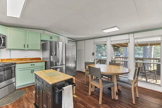 a kitchen with a table chairs refrigerator and cabinets