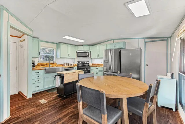 a kitchen with a table chairs refrigerator and cabinets