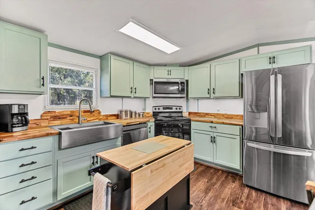 a kitchen with stainless steel appliances kitchen island granite countertop a refrigerator stove and sink