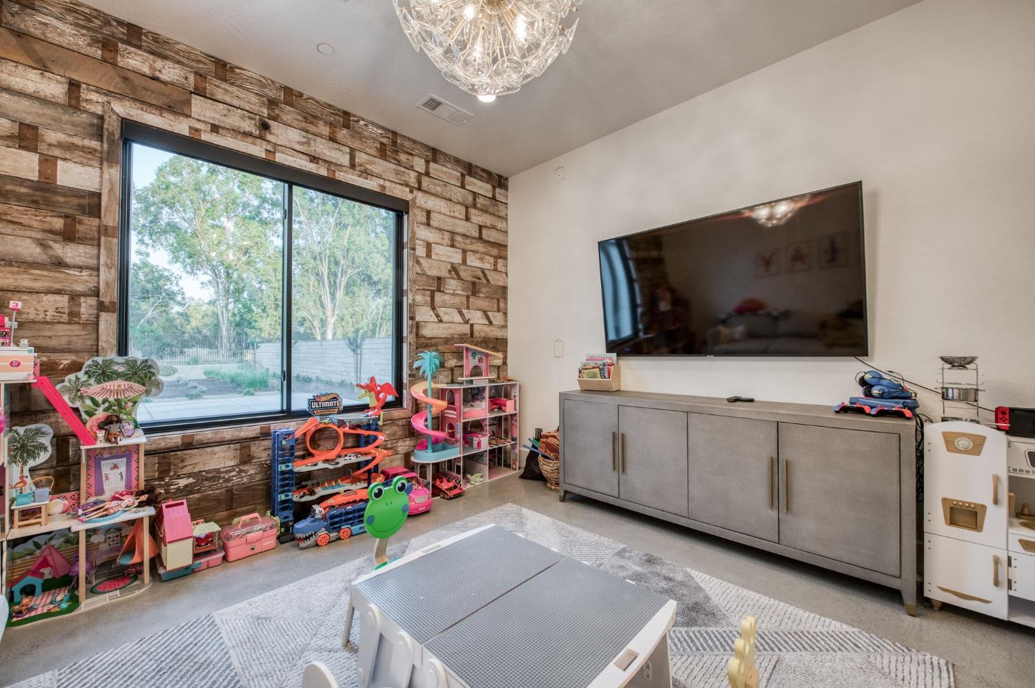 3895 East Reno Avenue Clovis, CA 93619 - Photo 25 of 67 a view of a room with baby toys and flat screen tv