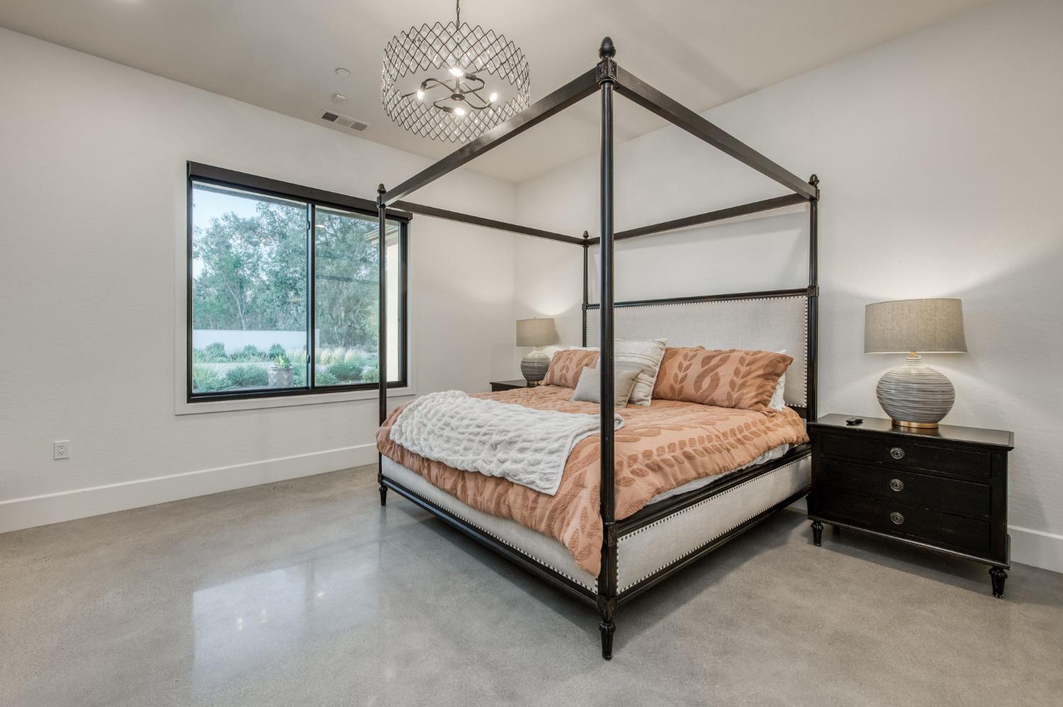 3895 East Reno Avenue Clovis, CA 93619 - Photo 26 of 67 a bedroom with a bed window and lamp on the dresser