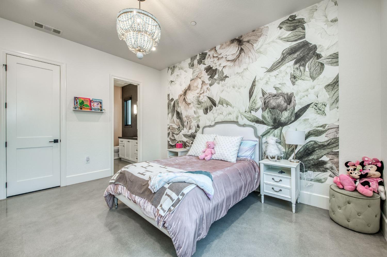 3895 East Reno Avenue Clovis, CA 93619 - Photo 33 of 67 a bedroom with a bed and a chandelier