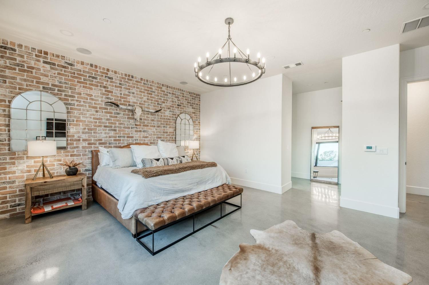 3895 East Reno Avenue Clovis, CA 93619 - Photo 37 of 67 a spacious bedroom with a bed mirror and a table