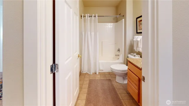 a bathroom with a granite countertop toilet a sink and shower