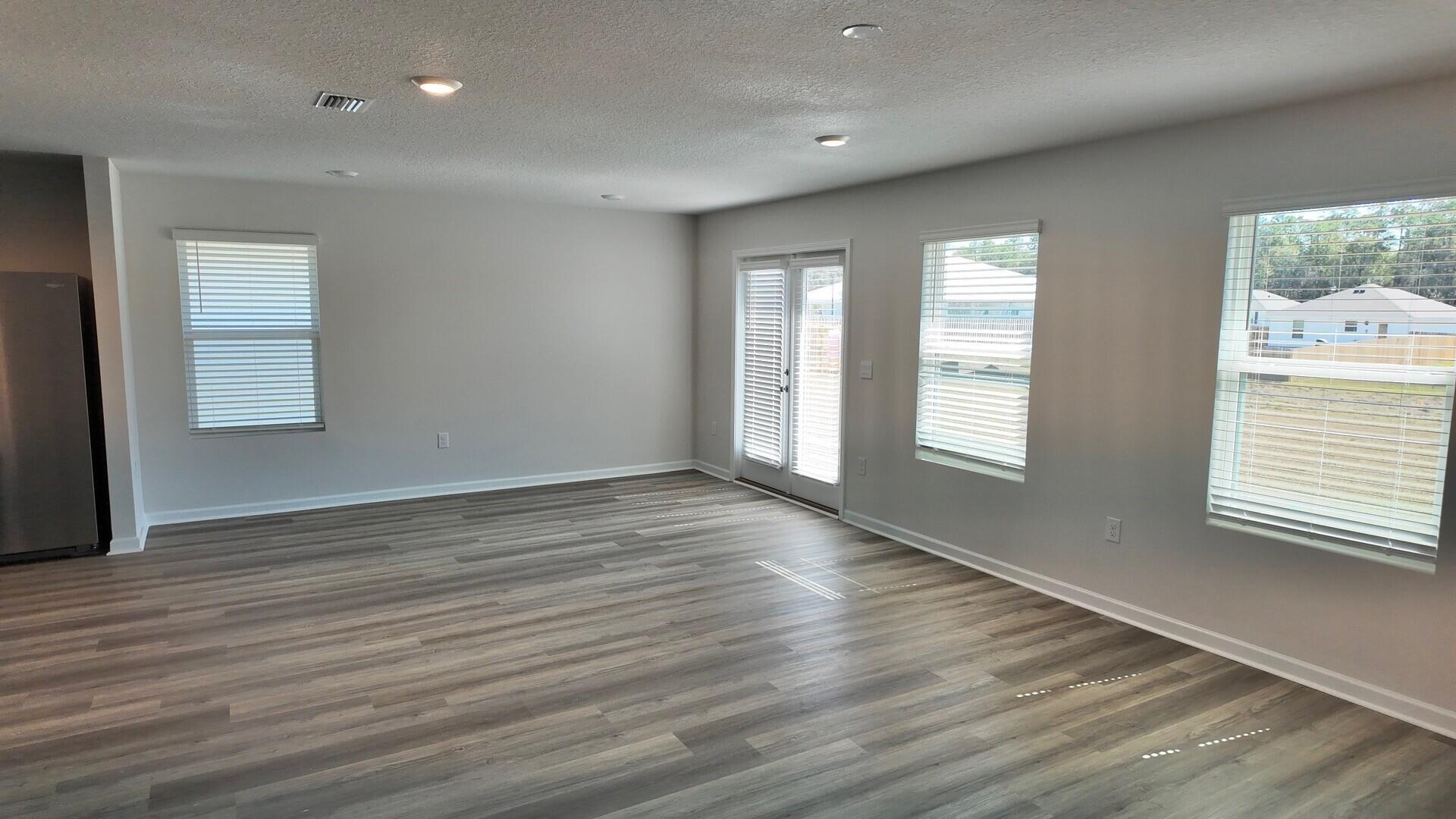 6356 Firefly Drive Milton, FL 32583 - Photo 13 of 44 an empty room with wooden floor and windows