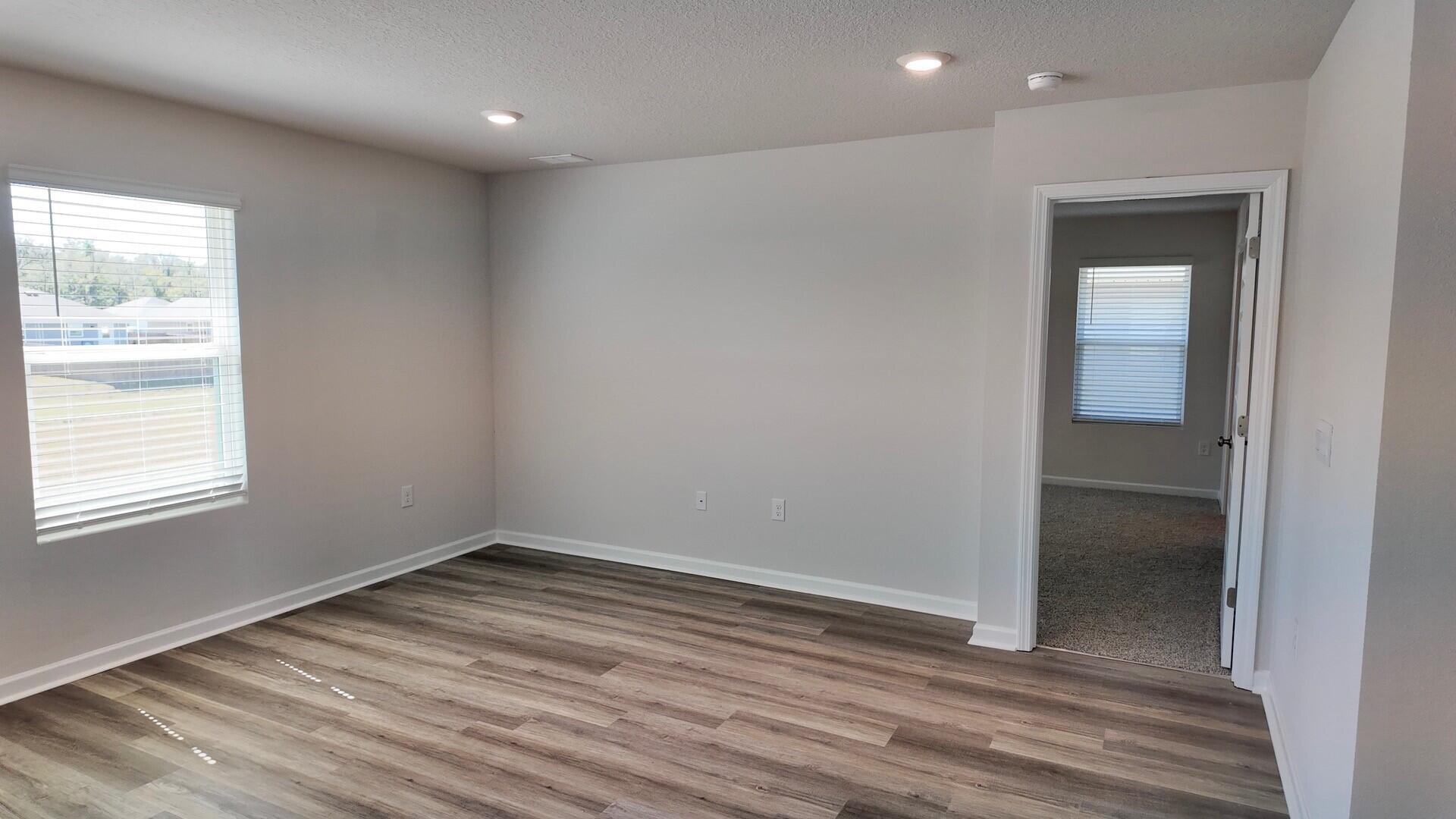 6356 Firefly Drive Milton, FL 32583 - Photo 14 of 44 an empty room with wooden floor and windows