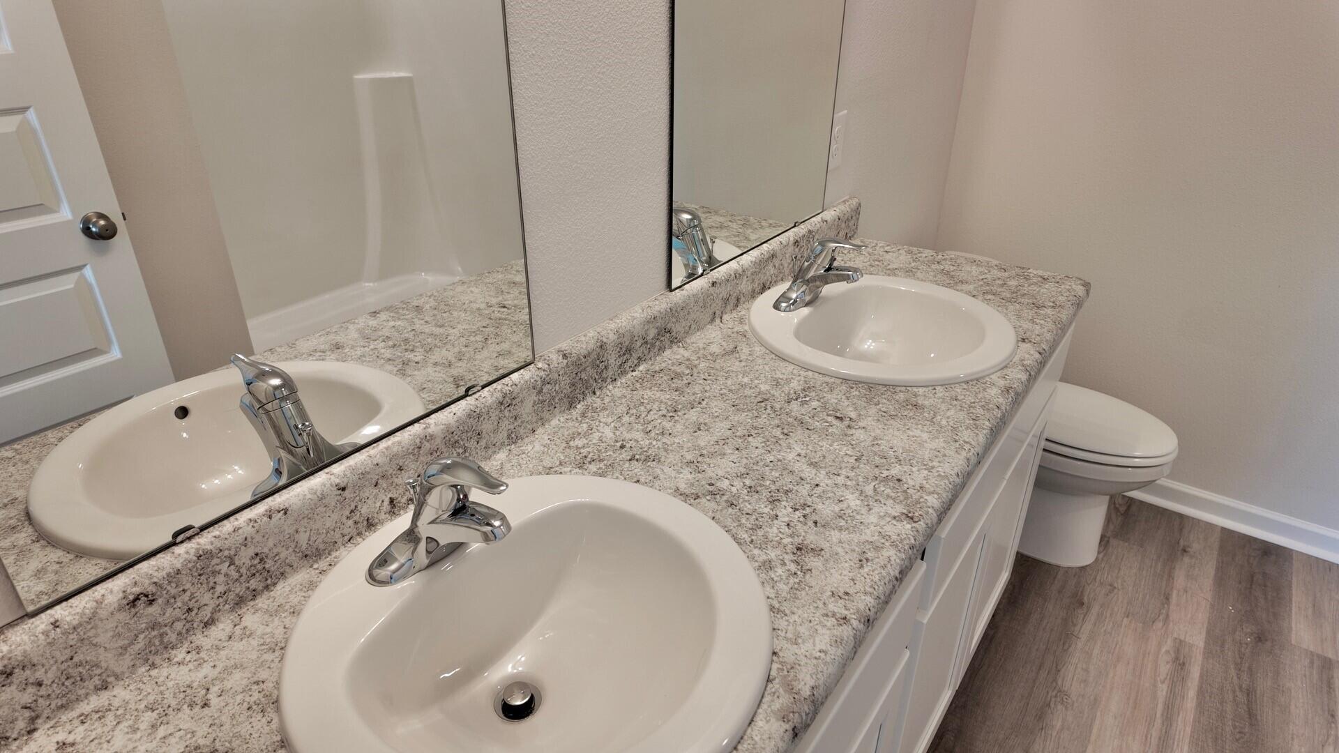 6356 Firefly Drive Milton, FL 32583 - Photo 20 of 44 a bathroom with a granite countertop sink a toilet and a mirror