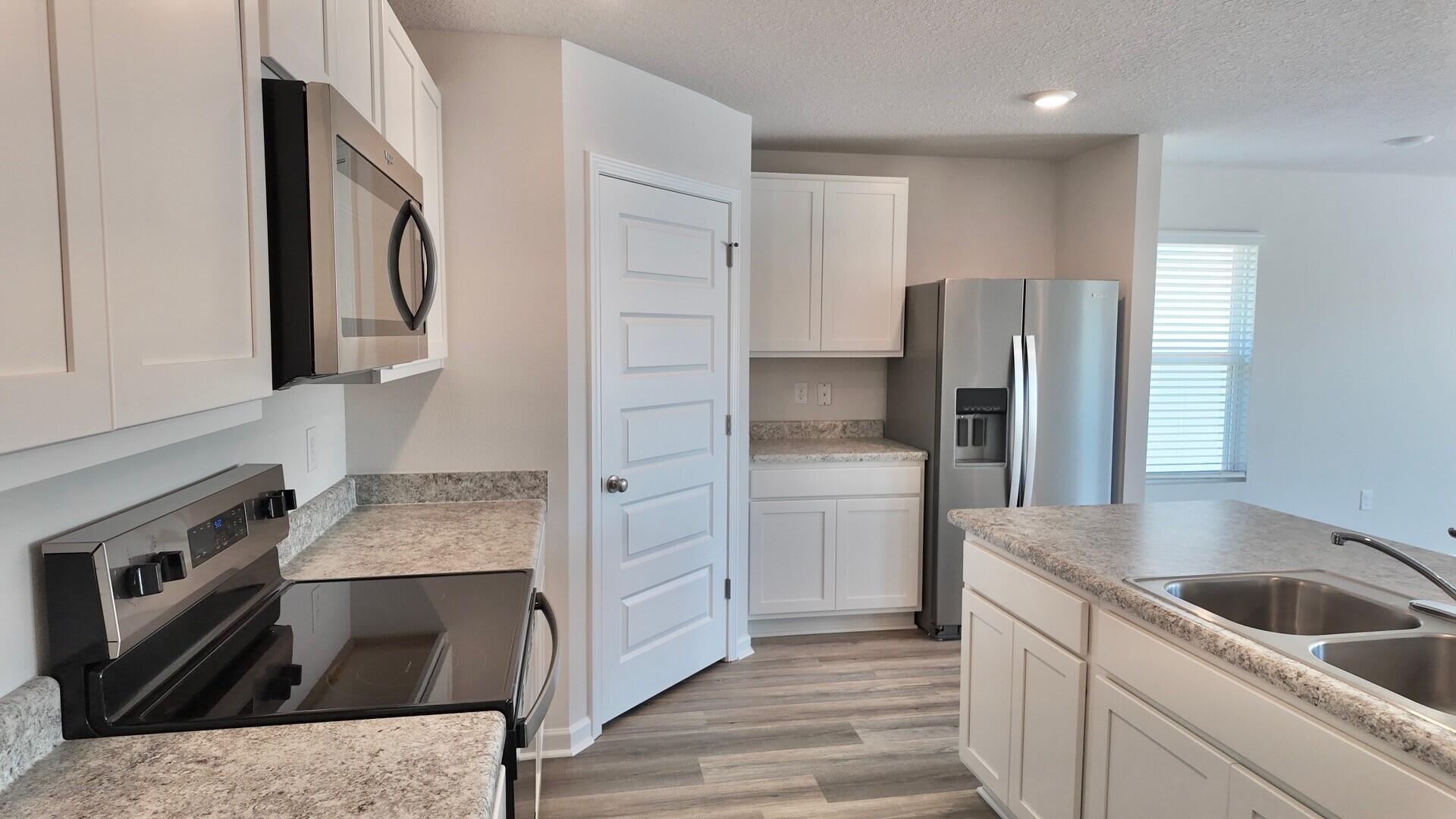 6356 Firefly Drive Milton, FL 32583 - Photo 3 of 44 a kitchen with a refrigerator sink and cabinets