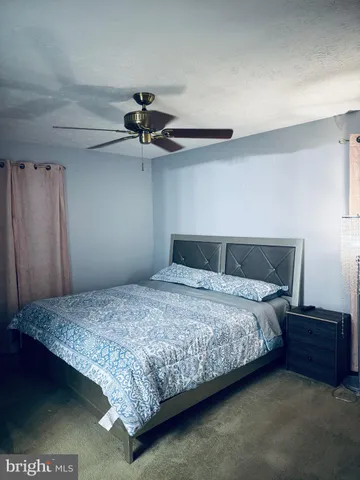 a bedroom with a bed and a ceiling fan