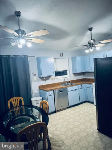 a kitchen with stainless steel appliances kitchen island granite countertop a table chairs in it and wooden floors