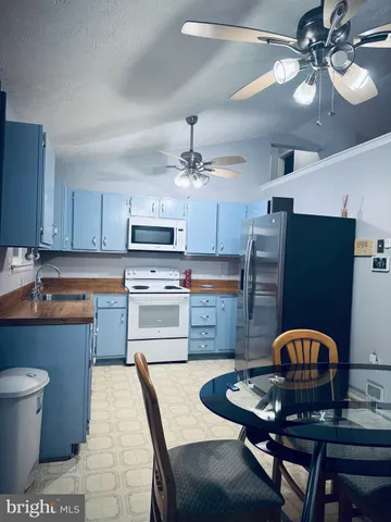 a kitchen with stainless steel appliances granite countertop a dining table and chairs