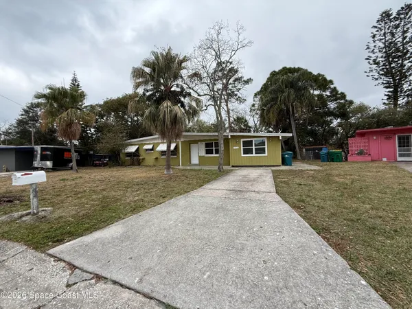 a view of a house with a yard and tree s