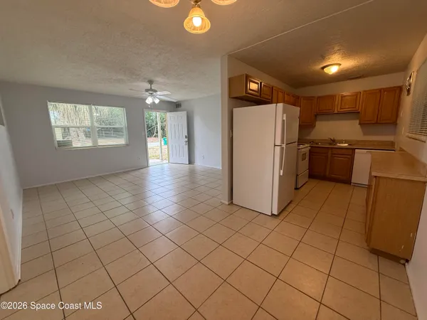 a view of a kitchen with a refrigerator and a stove top oven
