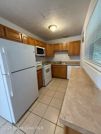 a kitchen with stainless steel appliances granite countertop a refrigerator a stove a sink and a microwave