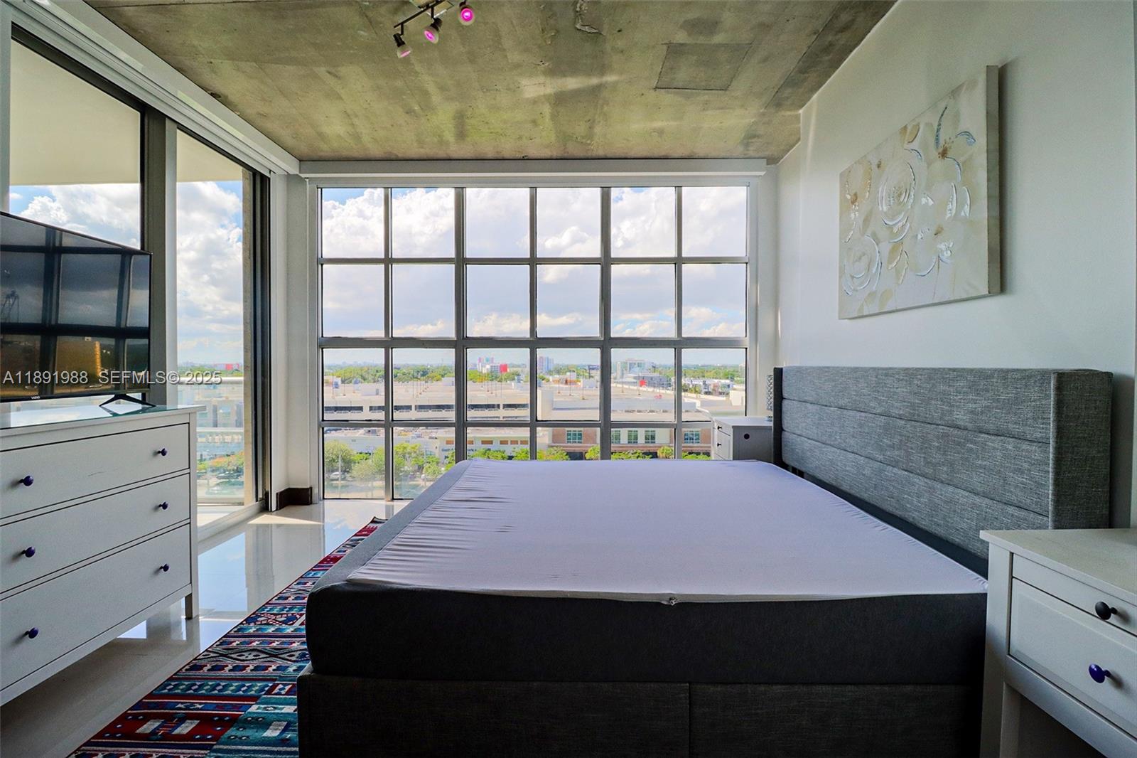 3451 Northeast 1st Avenue, Unit M0804 Miami, FL 33137 - Photo 16 of 39 a bed sitting in a bedroom next to a window