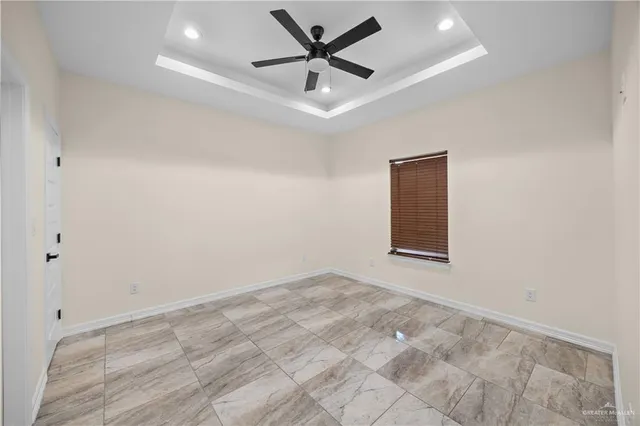 an empty room with a window and a ceiling fan